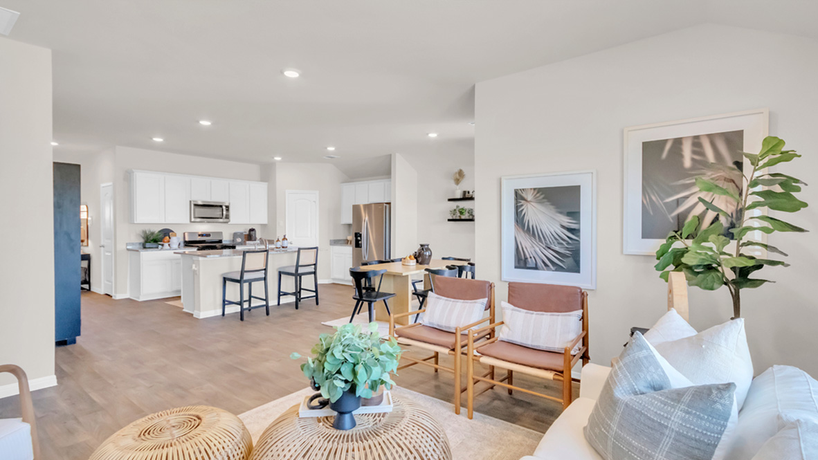 Open living with windows and laminated wood flooring.