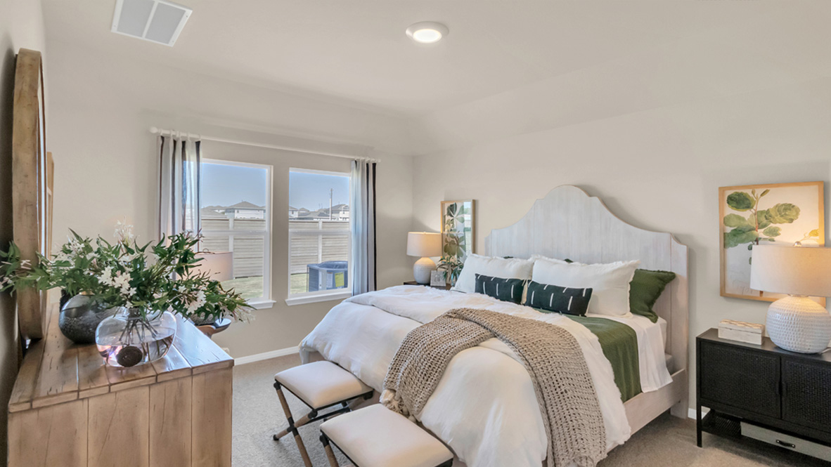 Main bedroom with carpeted floors and window.