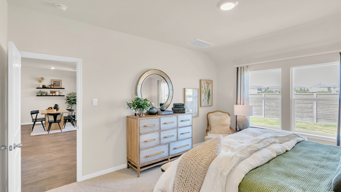 Main bedroom with carpeted floors and window.