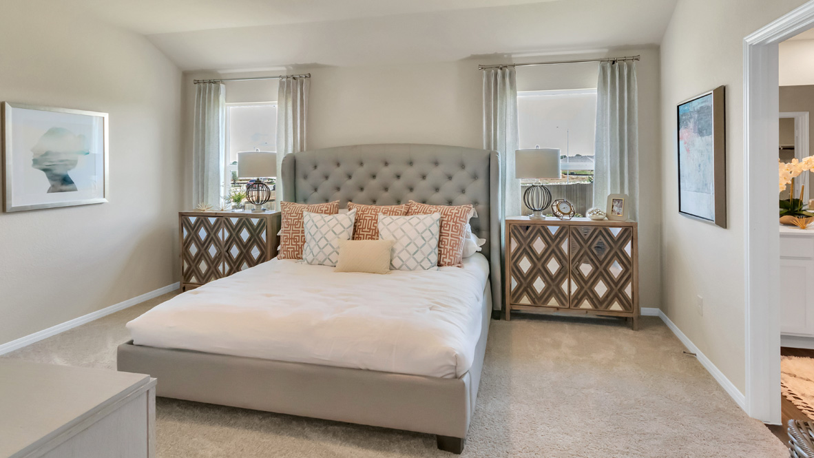 bedroom with an upholstered king bed, with night stands and windows on either side