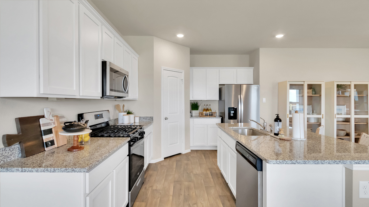 spacious kitchen with white cabinetry, large island and stainless steel appliances