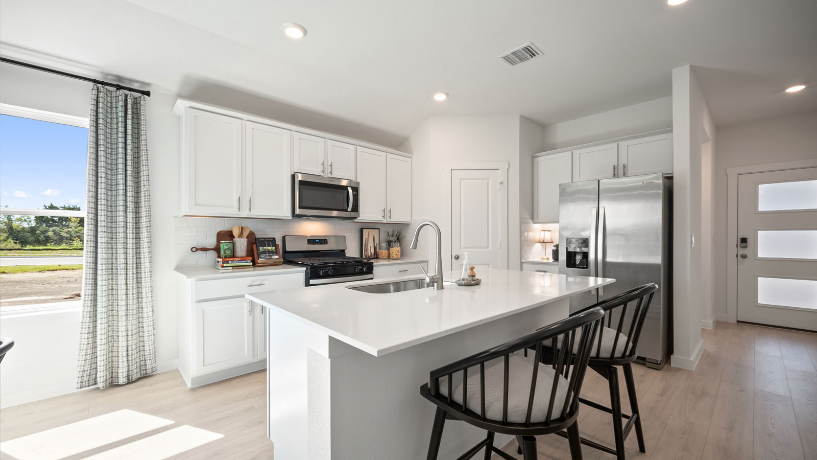 Gourmet kitchen with quartz countertops and decorative backsplash.