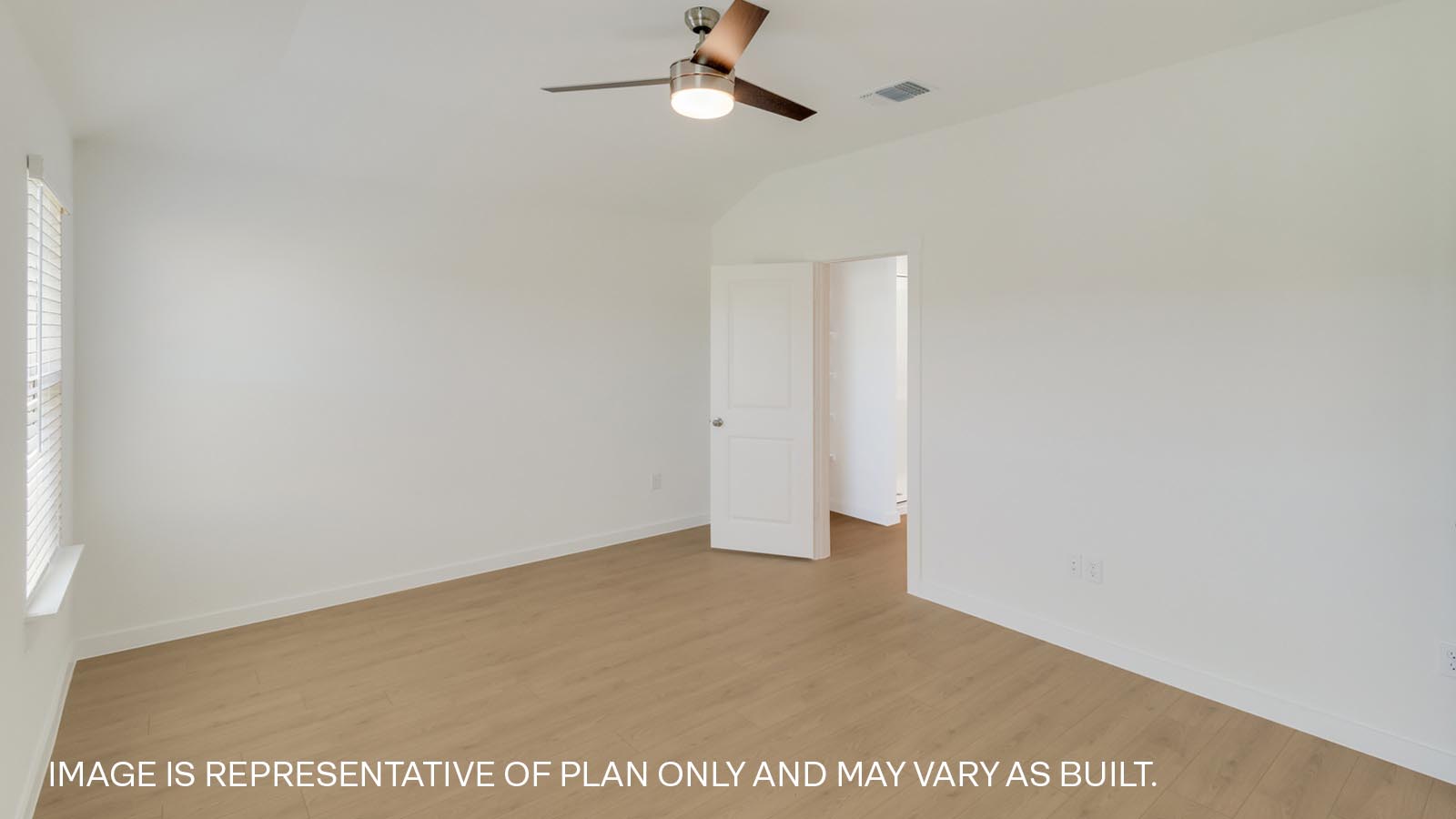 Spacious primary bedroom with two windows and ceiling fan.
