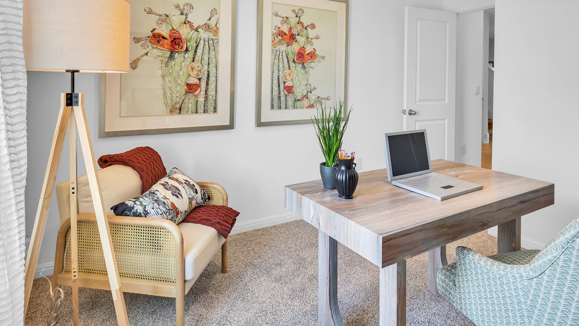bedroom turned into a home office featuring a desk, bookshelves and a window