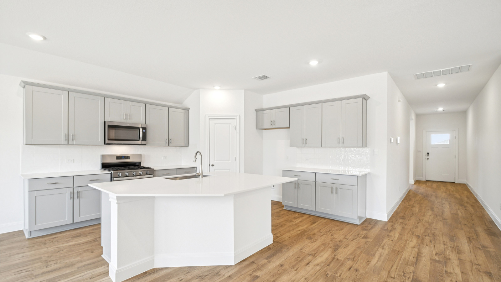 Beautiful kitchen with quartz countertops and decorative style backsplash.
