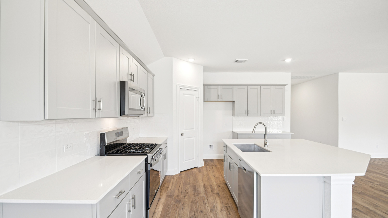 Beautiful kitchen with quartz countertops and decorative style backsplash.