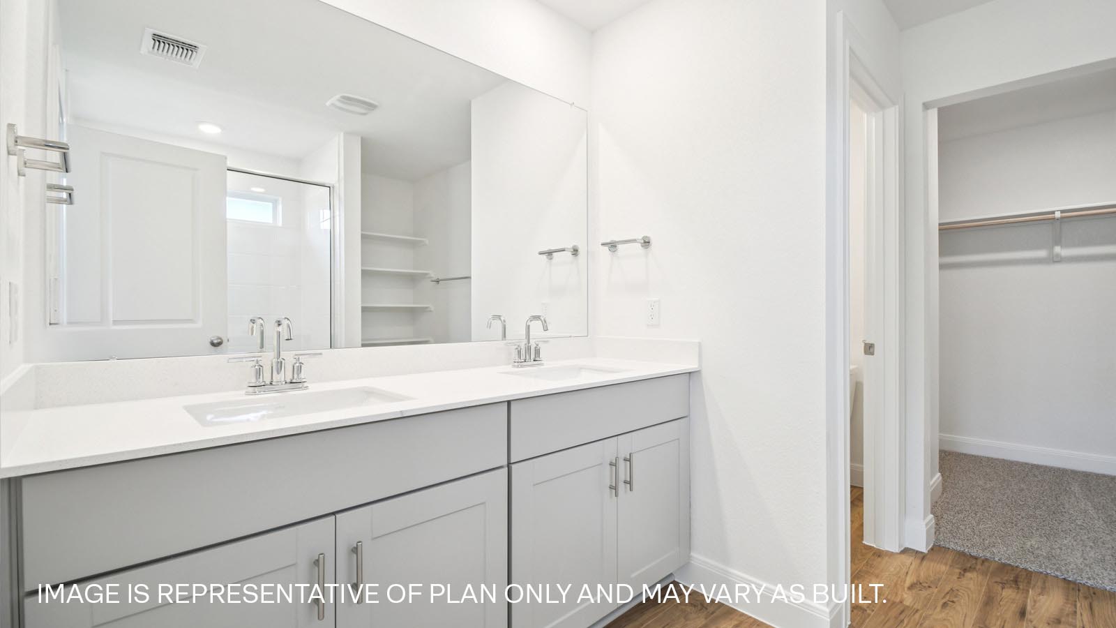 Double vanity sink and walk-in shower in primary bathroom.