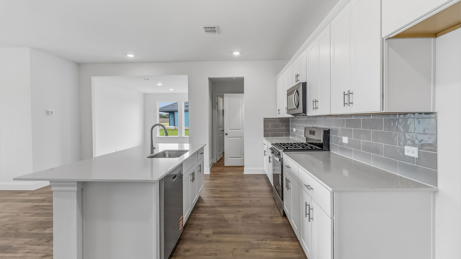 Kitchen with decorative backsplash and quartz countertops.