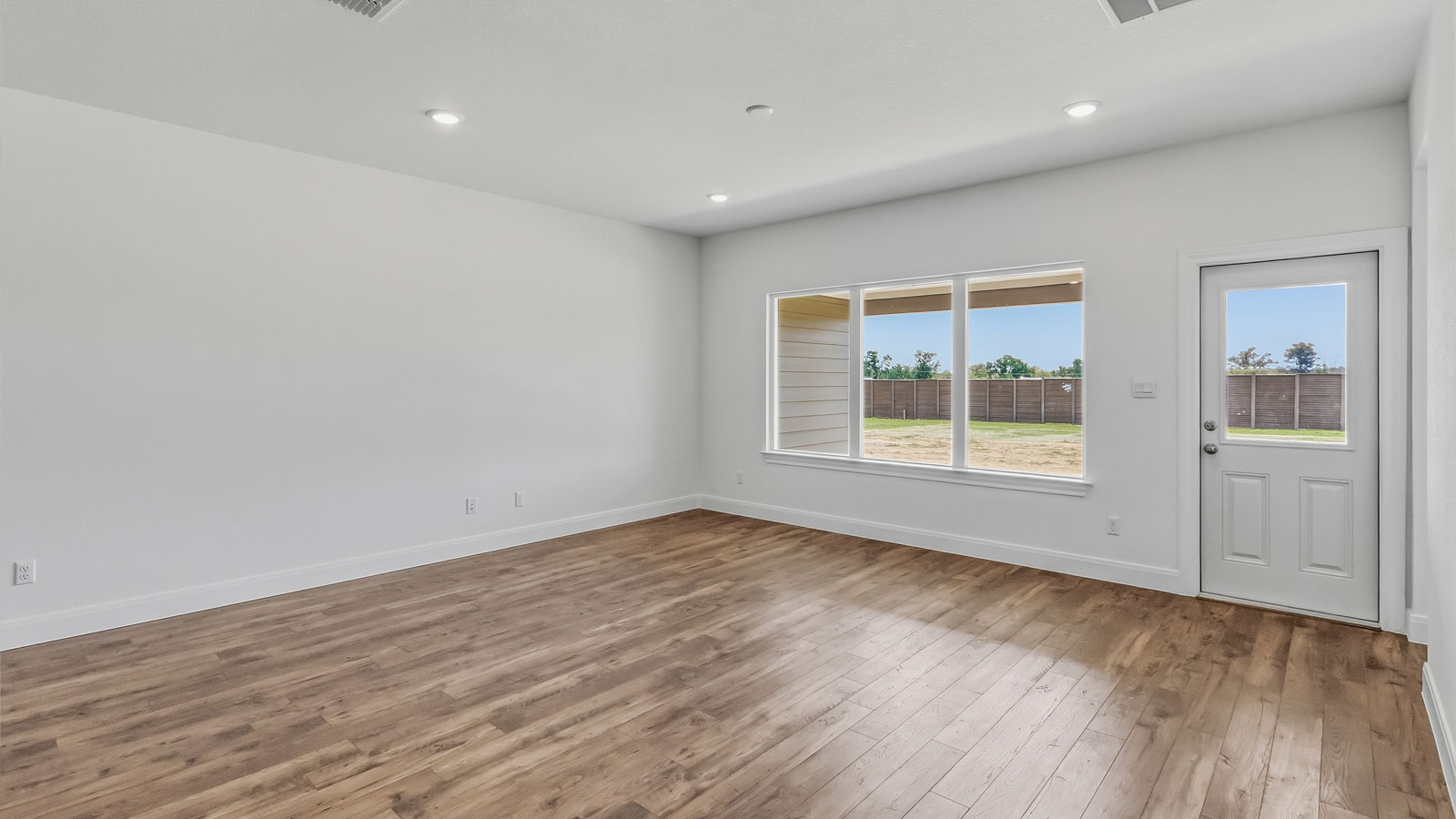 Open living area with laminated wood flooring.