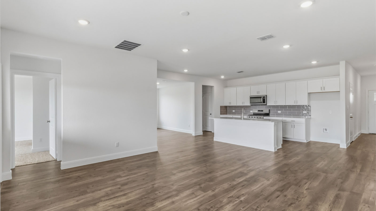 Open living area with laminated wood flooring.