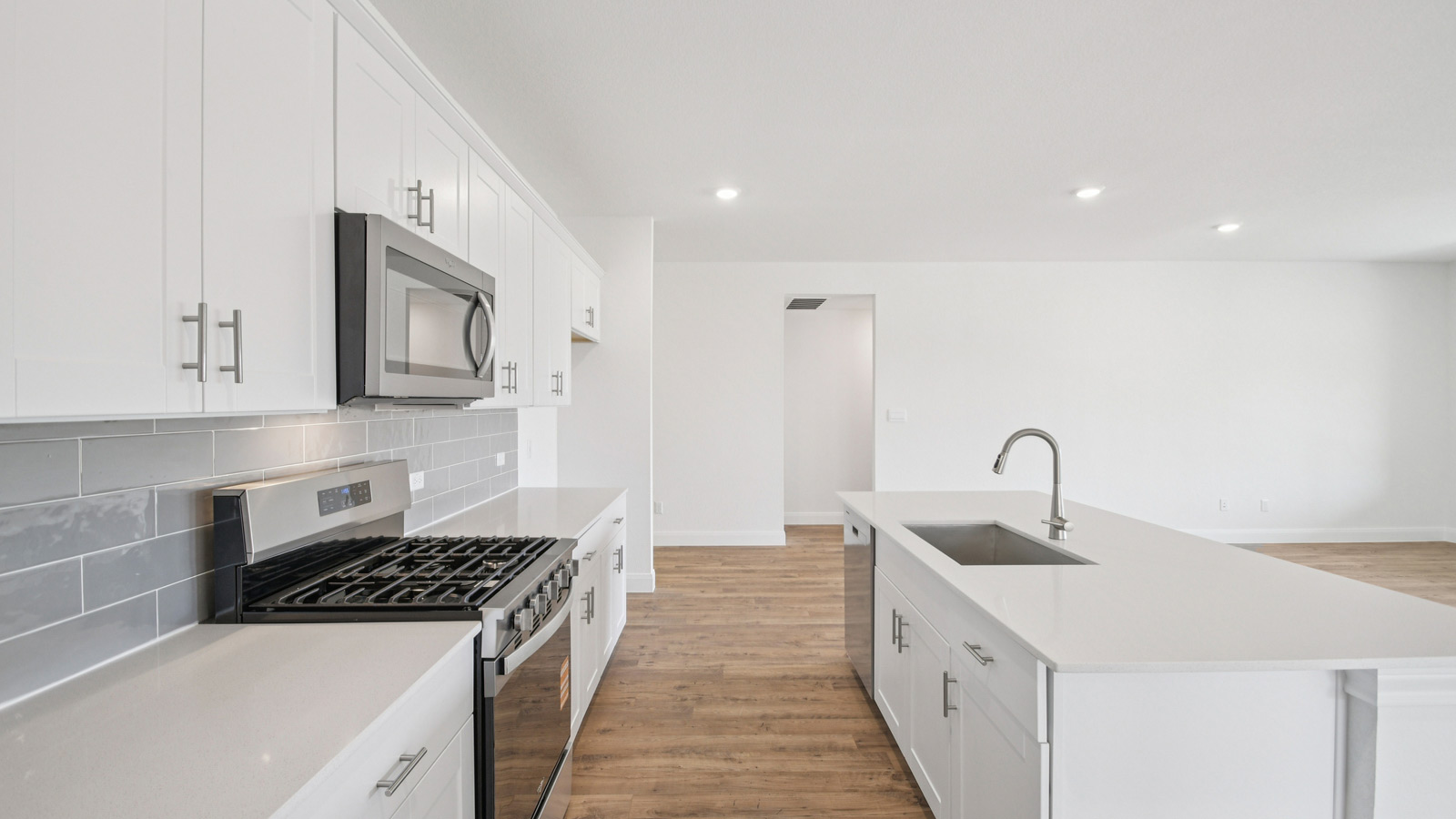 Gourmet kitchen with quartz countertops and decorative tile backsplash.