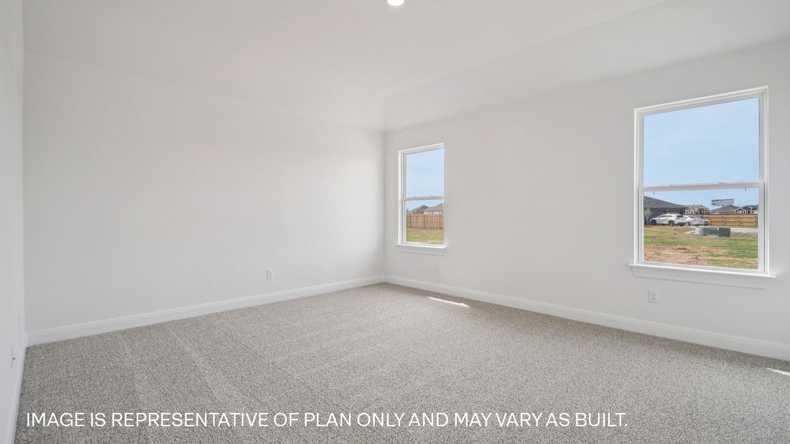 Spacious primary bedroom with two windows.