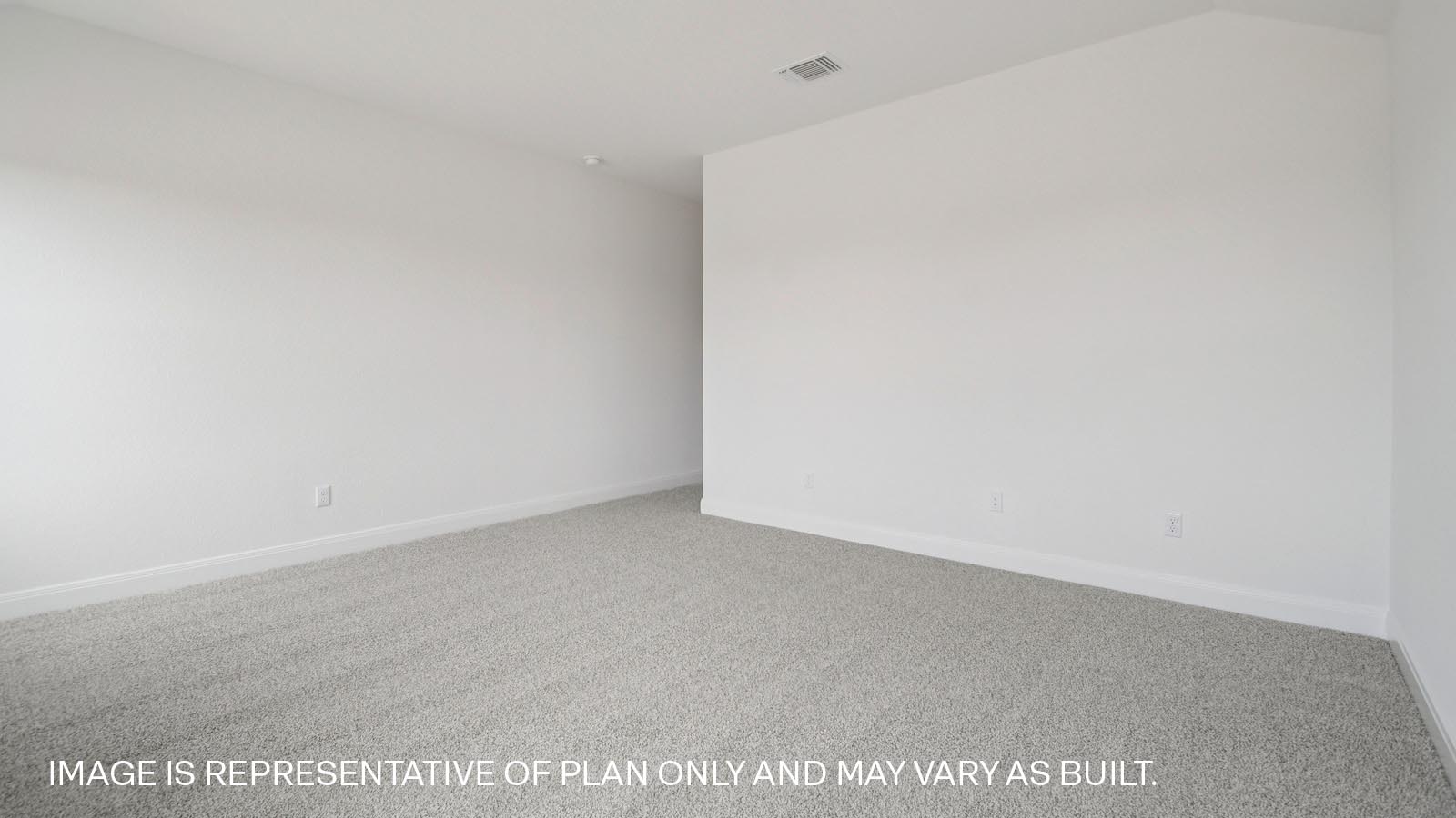 Spacious primary bedroom with two windows.