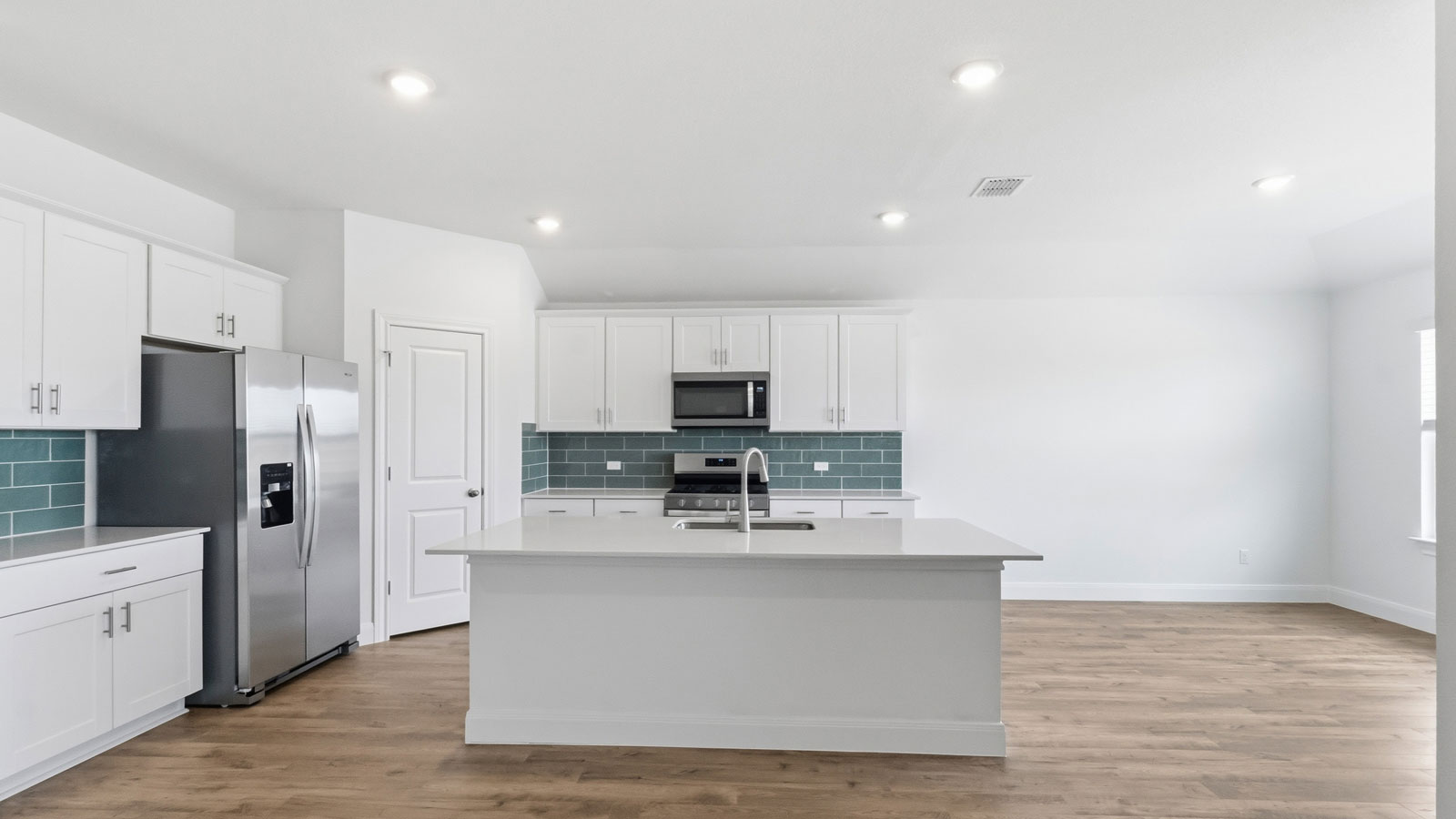 Beautiful kitchen with quartz countertops and tile backsplash.