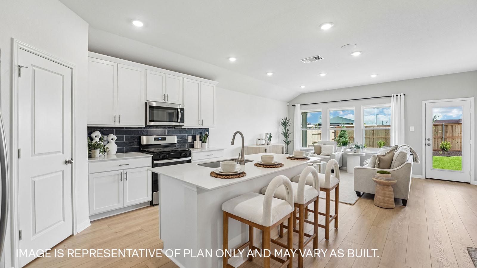 Modern kitchen with quartz countertops and tile backsplash.