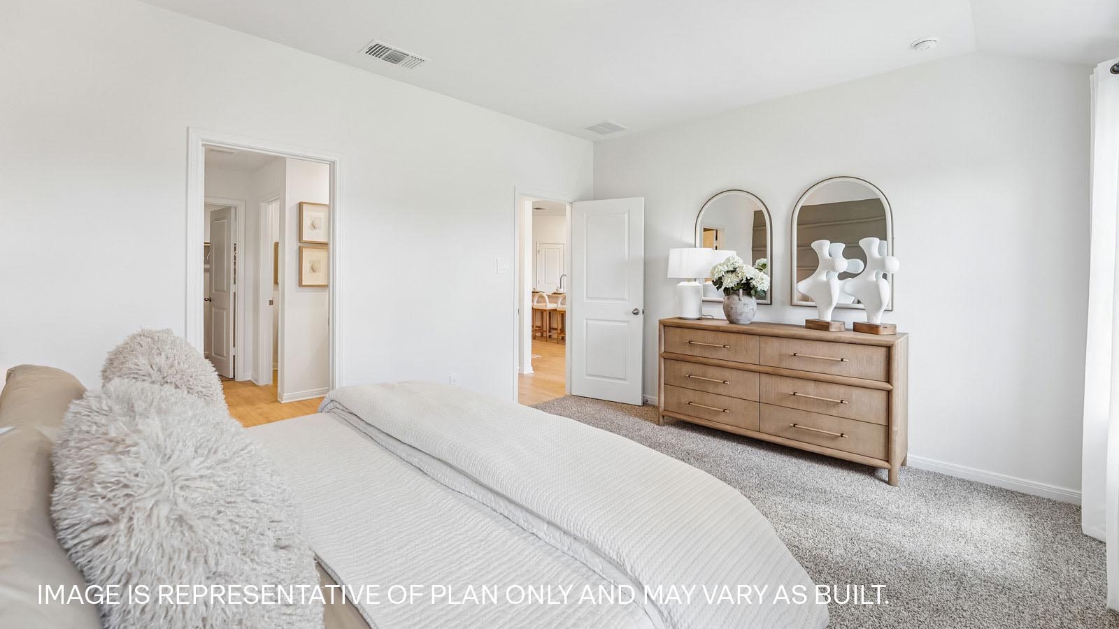 Primary bedroom with carpeted flooring and two large windows.