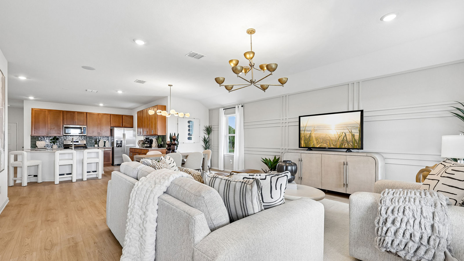 Open living area with premium laminate wood flooring at Kingston model home at Revelry in Del Valle, TX.