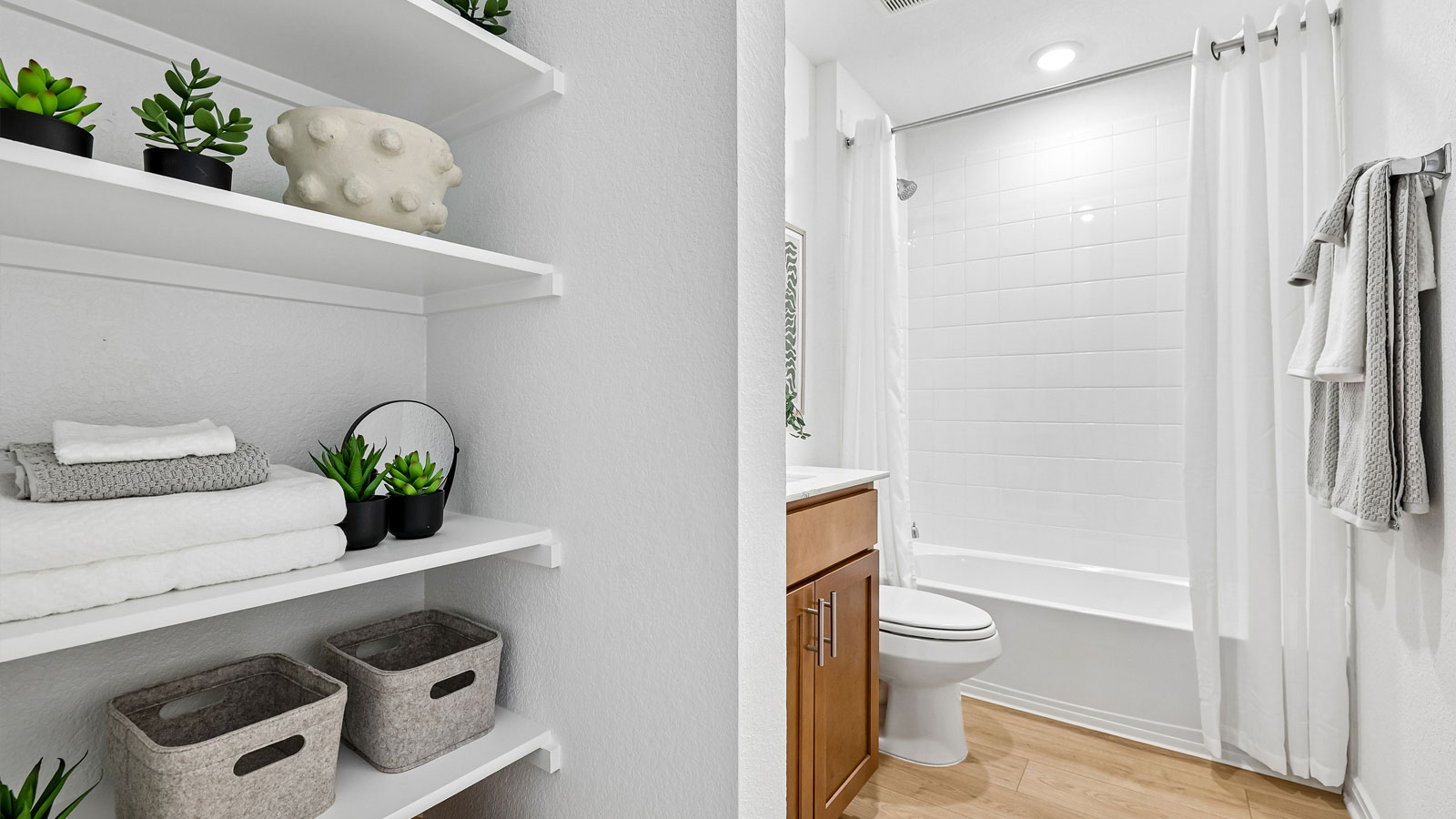 Secondary bathroom with raised shower head and bathtub.