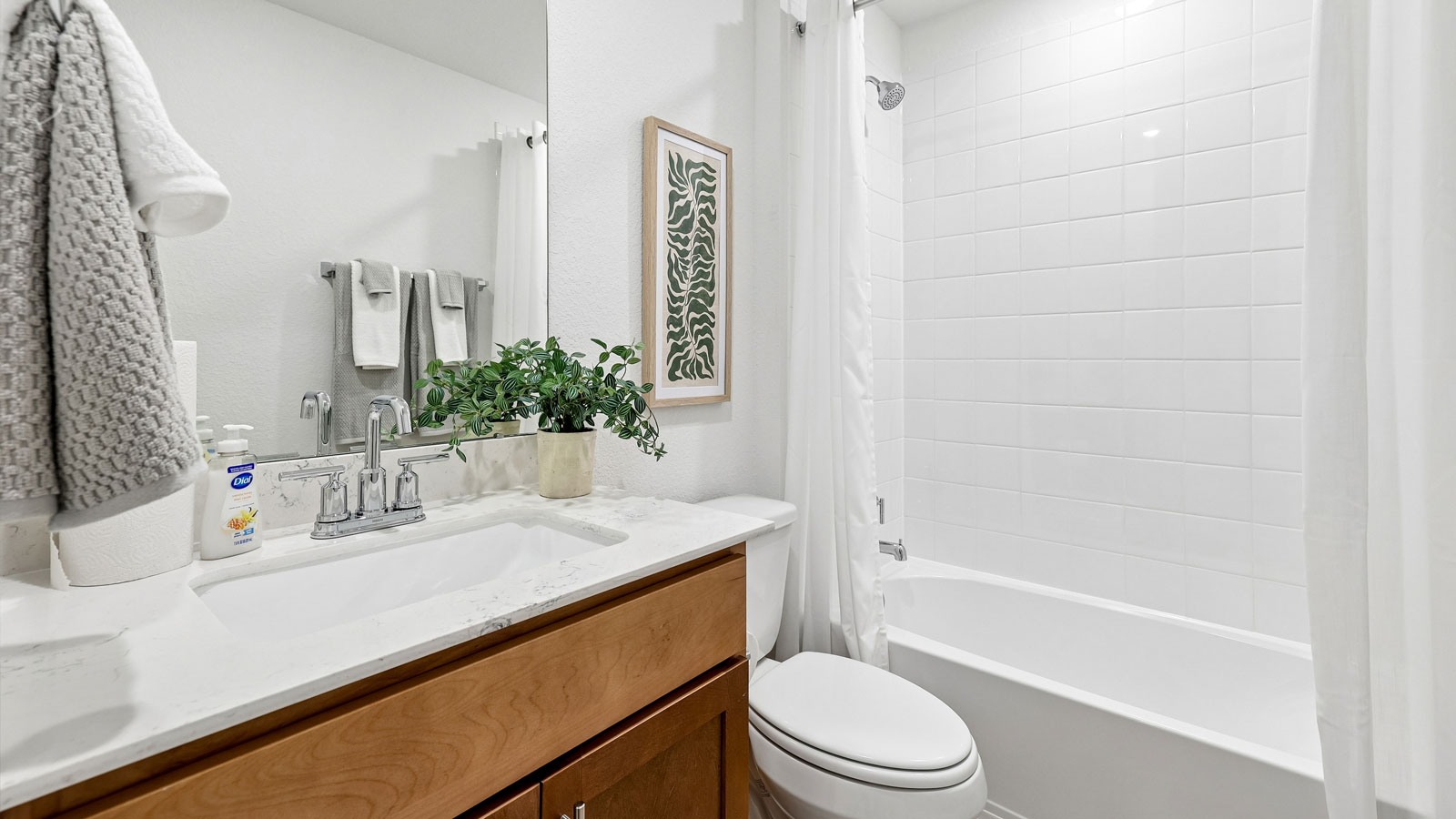 Secondary bathroom with raised shower head and bathtub.