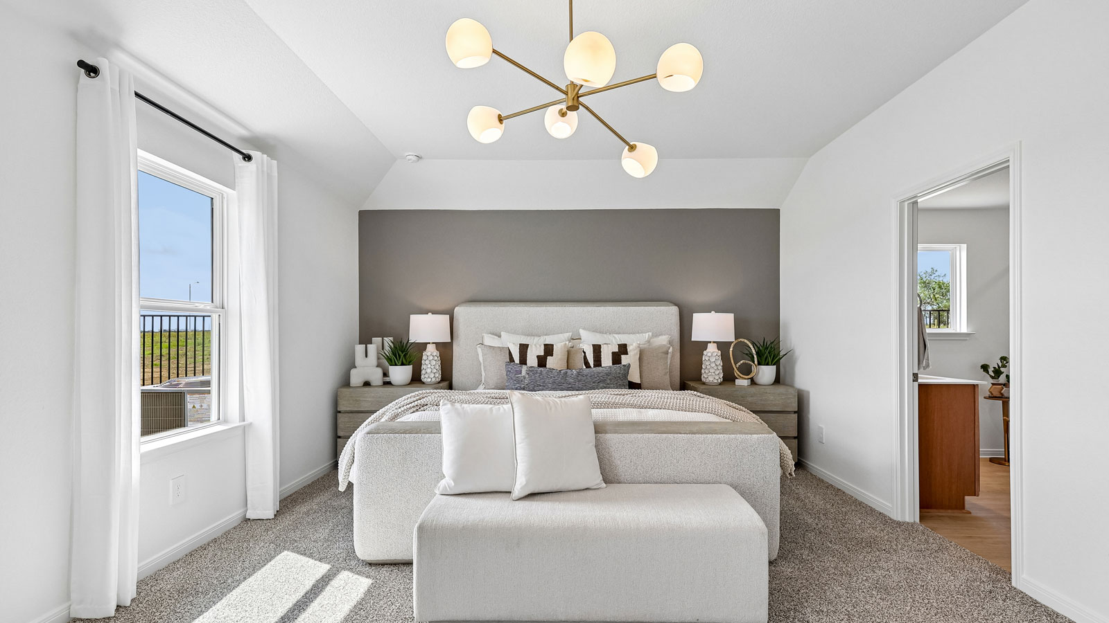Spacious primary bedroom with carpeted flooring and ensuite bathroom.