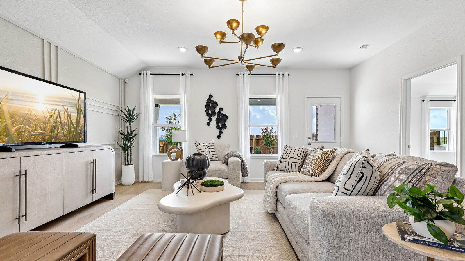 Open living area with premium laminate wood flooring at Kingston model home at Revelry in Del Valle, TX.