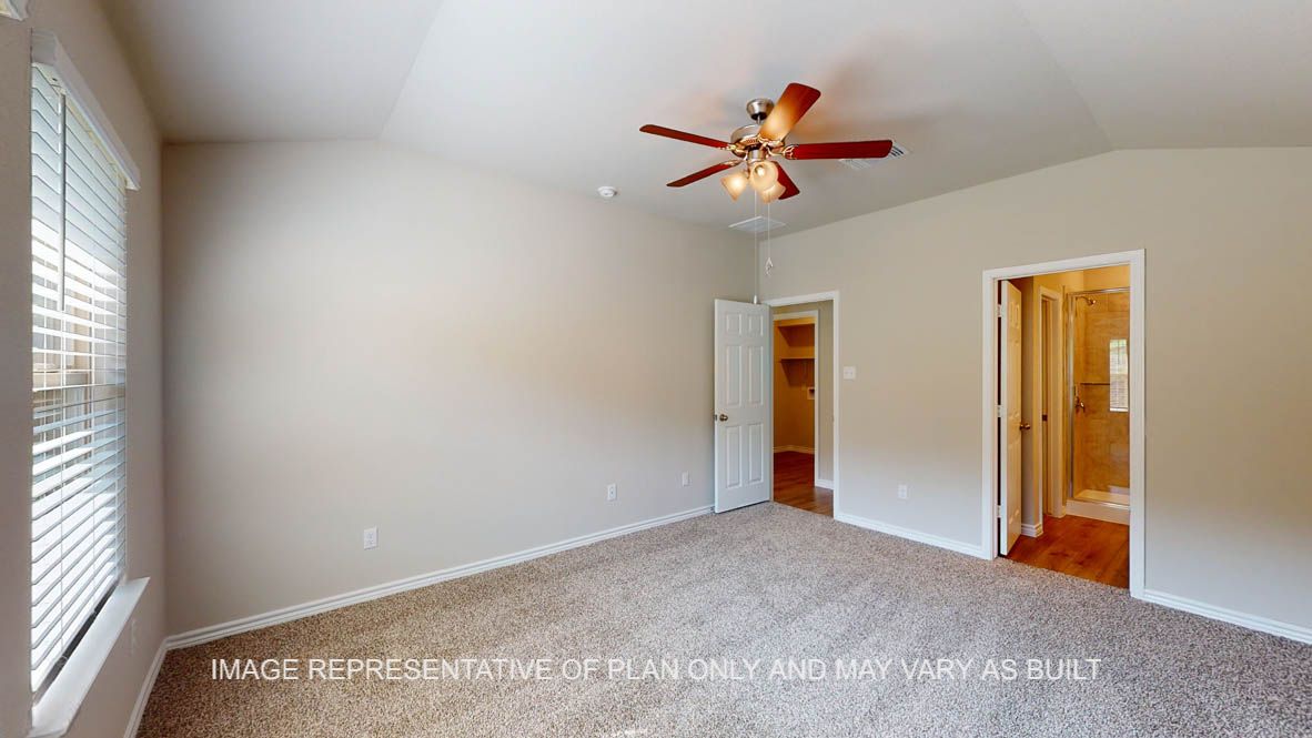 Auburn primary bedroom with carpet flooring and windows.