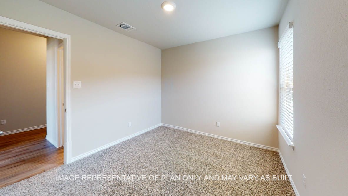 Auburn secondary bedroom with carpet flooring and windows.