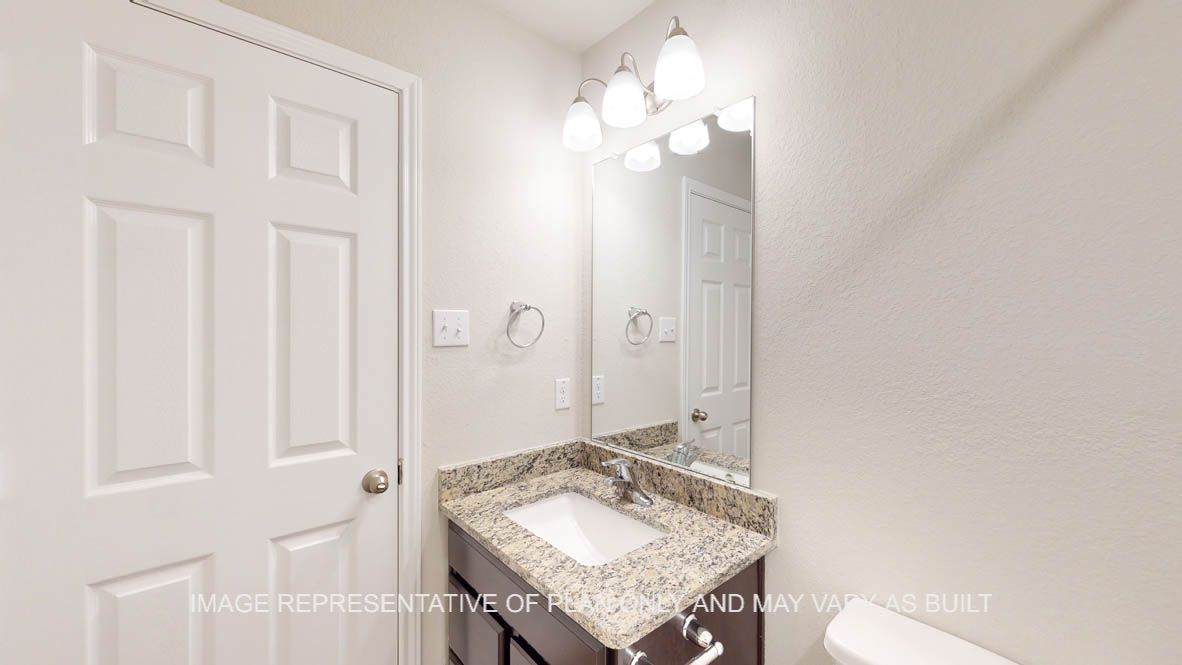 Auburn secondary bathroom with dark cabinets and granite countertops.