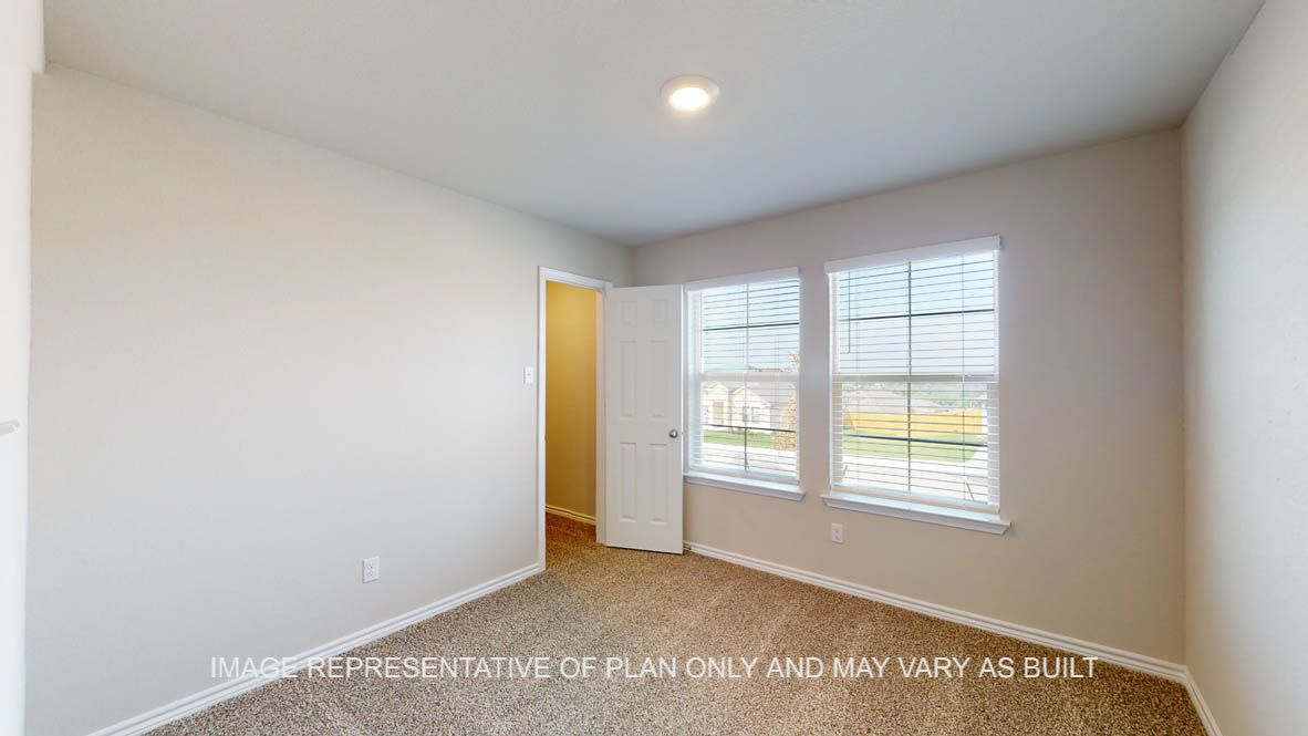 Auburn secondary bedroom with carpet flooring and windows.
