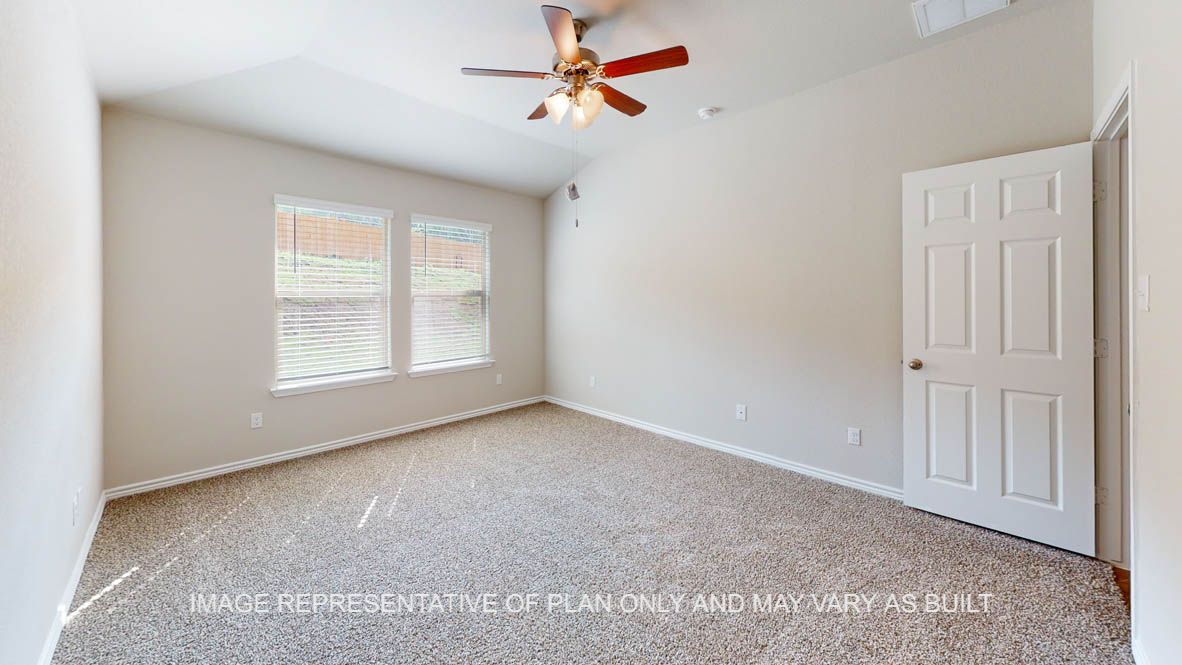 Auburn secondary bedroom with carpet flooring and windows.