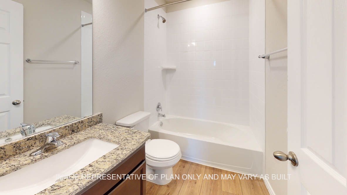 Auburn secondary bathroom with dark cabinets and granite countertops.