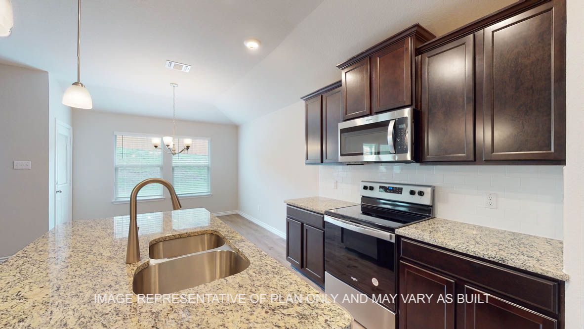 Auburn kitchen with dark cabinets and granite countertops.
