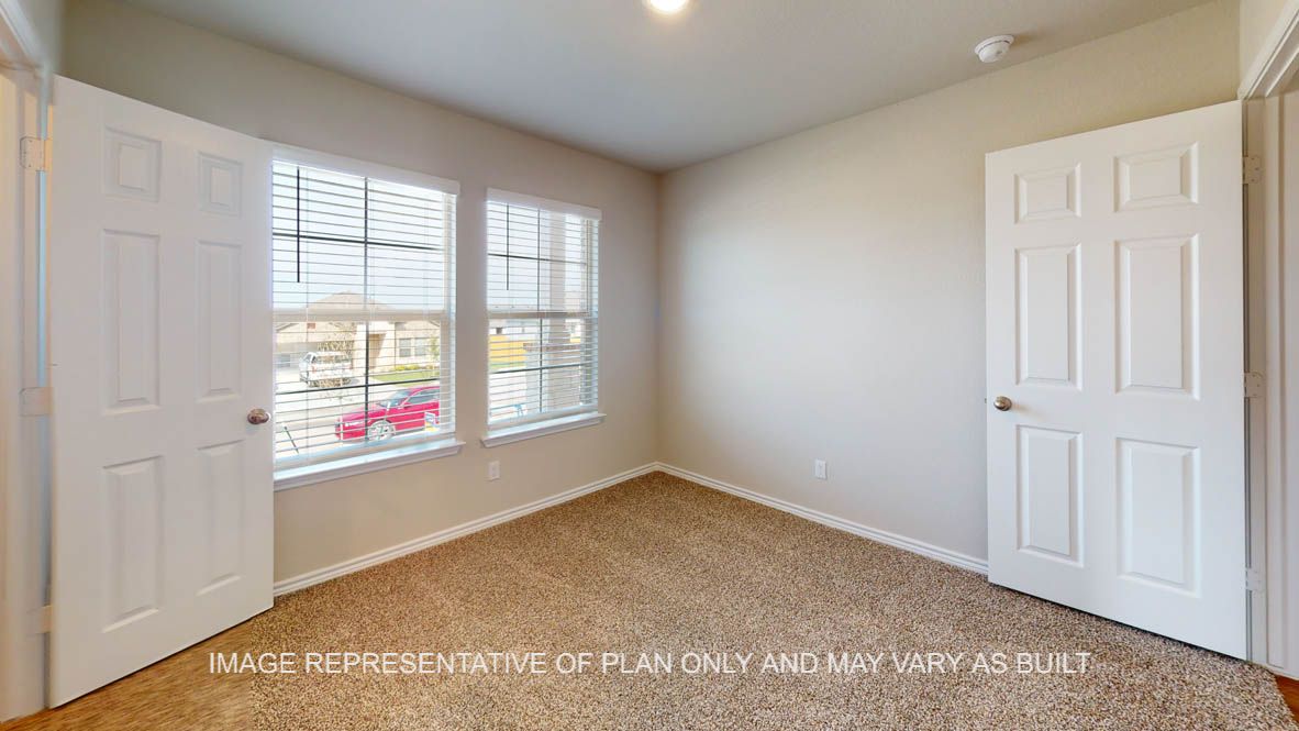 Auburn secondary bedroom with carpet flooring and windows.
