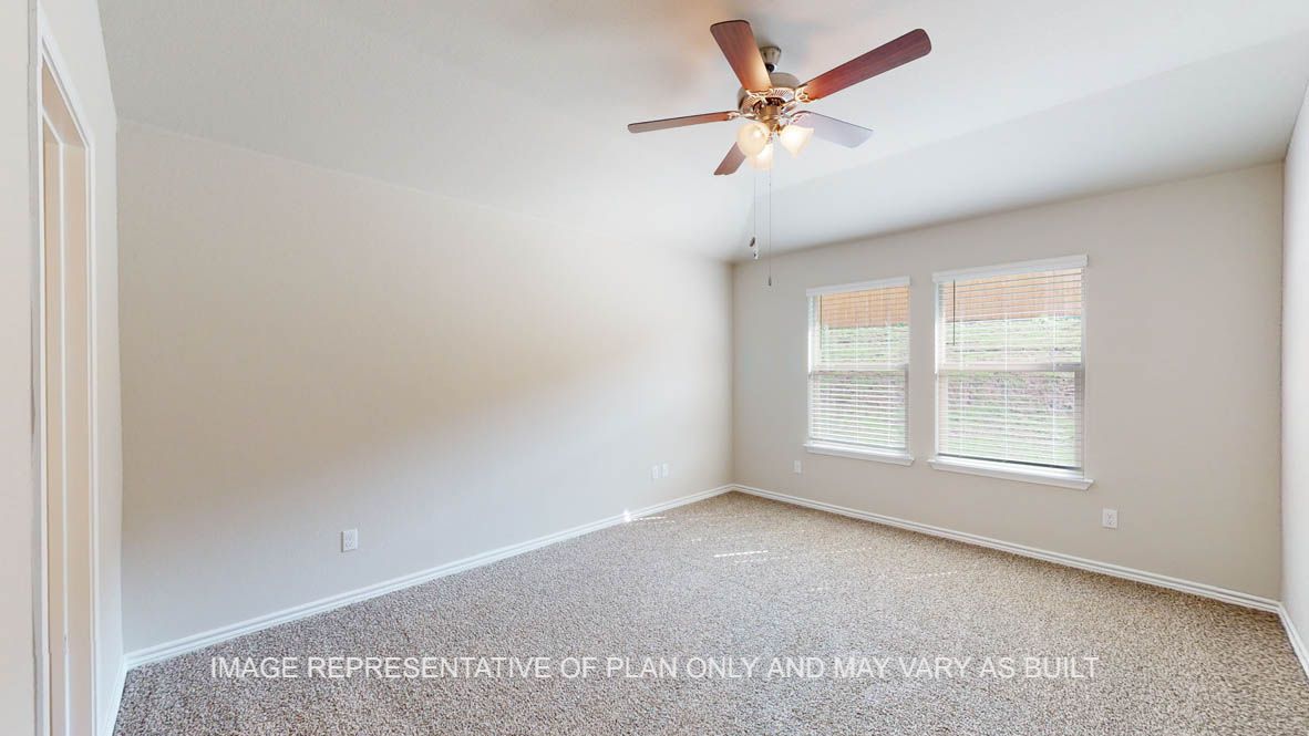 Auburn primary bedroom with carpet flooring and windows.