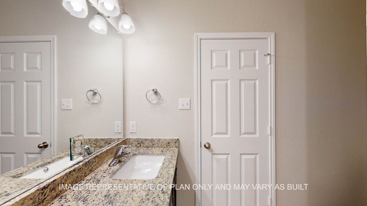 Auburn primary bathroom with granite countertops.