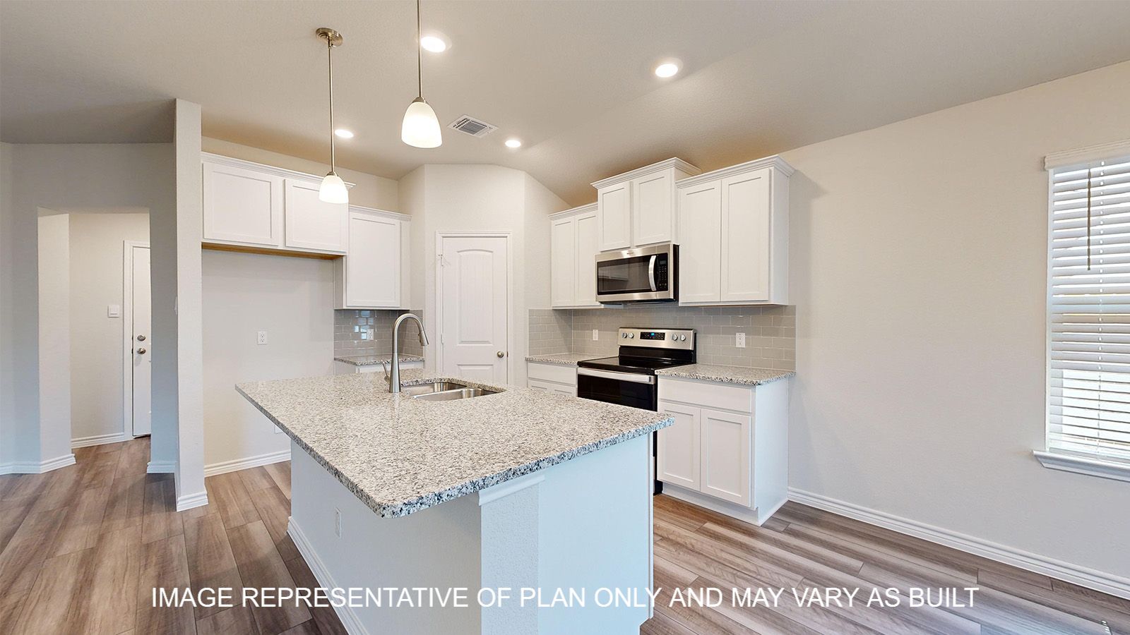 Alpine kitchen with white cabinets and granite countertops.