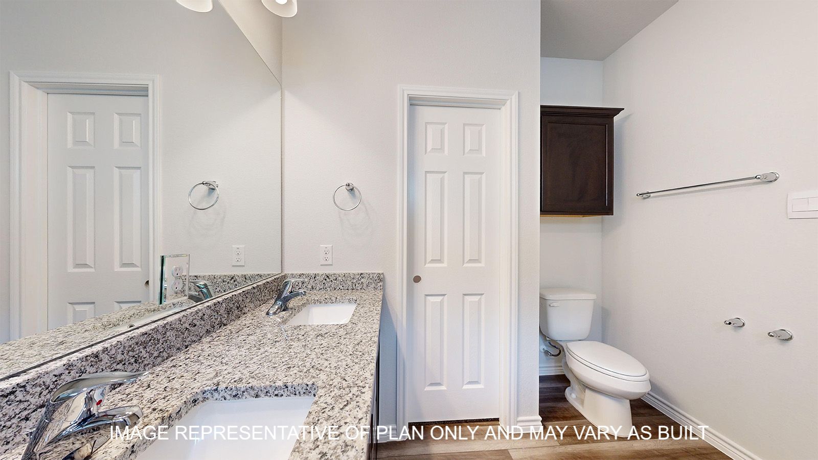 Dakota primary bathroom with dual vanities and dark cabinets.