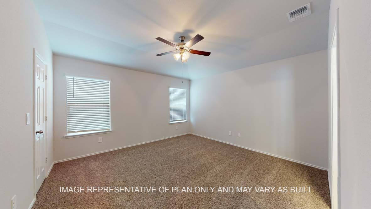 Roosevelt primary bedroom with carpet flooring and windows.