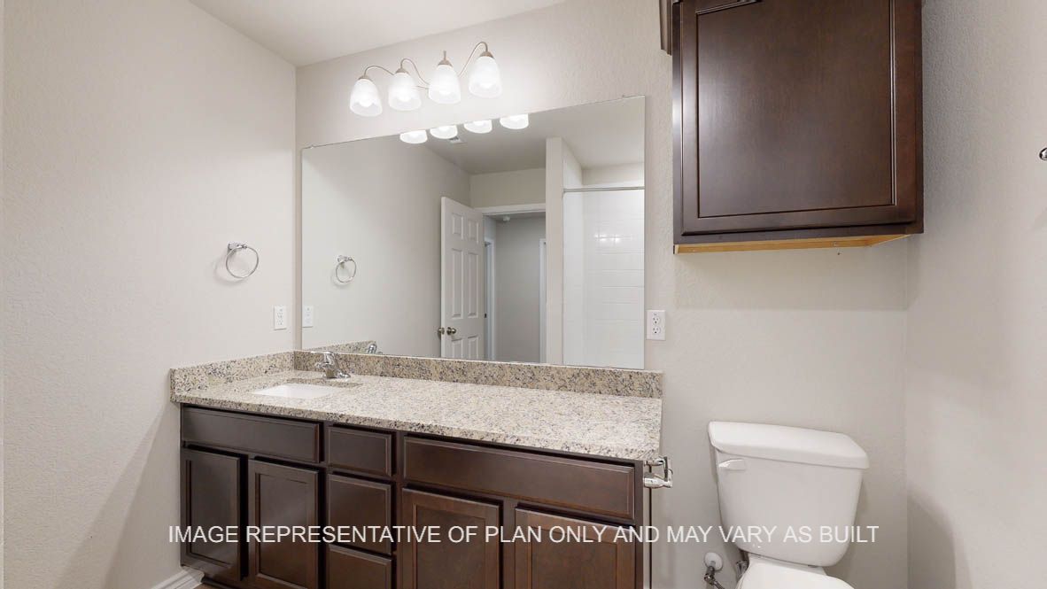 Richmond secondary bathroom with dark cabinets and granite countertops.