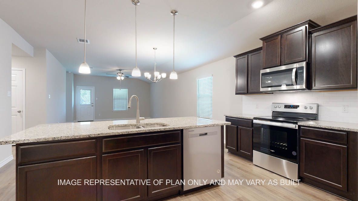 Richmond kitchen with center island and undermount sink with pendants lights above island.