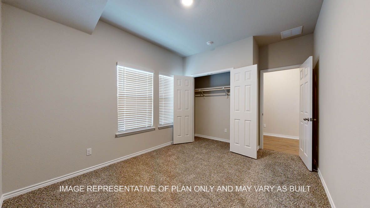 Richmond secondary bedroom with carpet flooring and closet and windows.