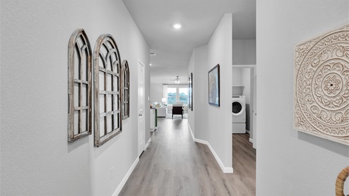 Creekfall model home entry hallway with view of the living room and the utility room.