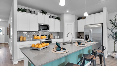 Creekfall model home kitchen with granite counter and island.