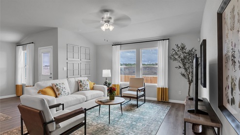 Creekfall model home living room with view of the back door and back yard.