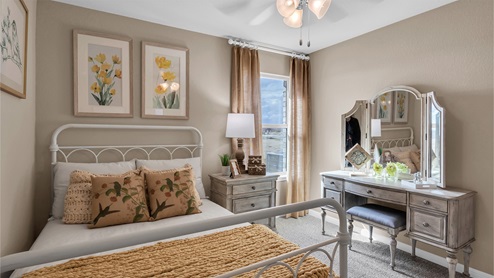 Creekfall model home secondary bedrrom with full-size bed and accent decor.