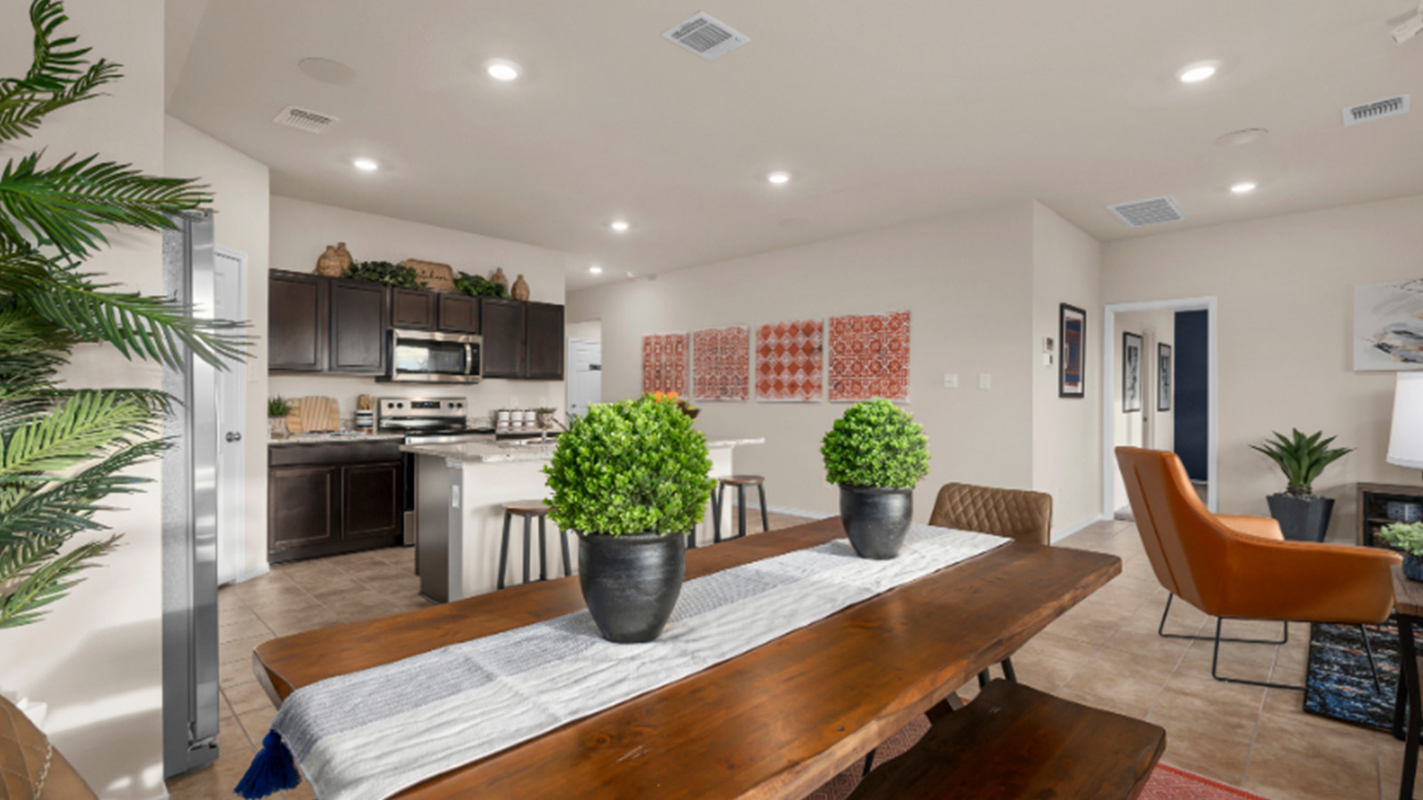 Yowell Ranch Model Home dining room with dining room table and view of open concept kitchen and living room.