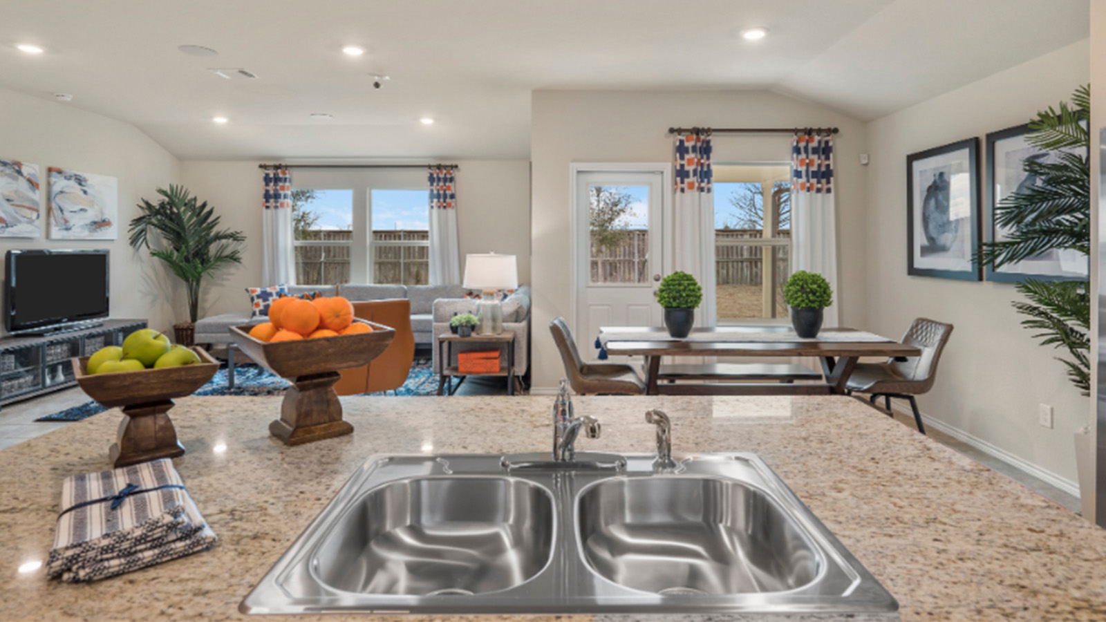 Yowell Ranch Model Home kitchen with kitchen island and view of open concept living room.