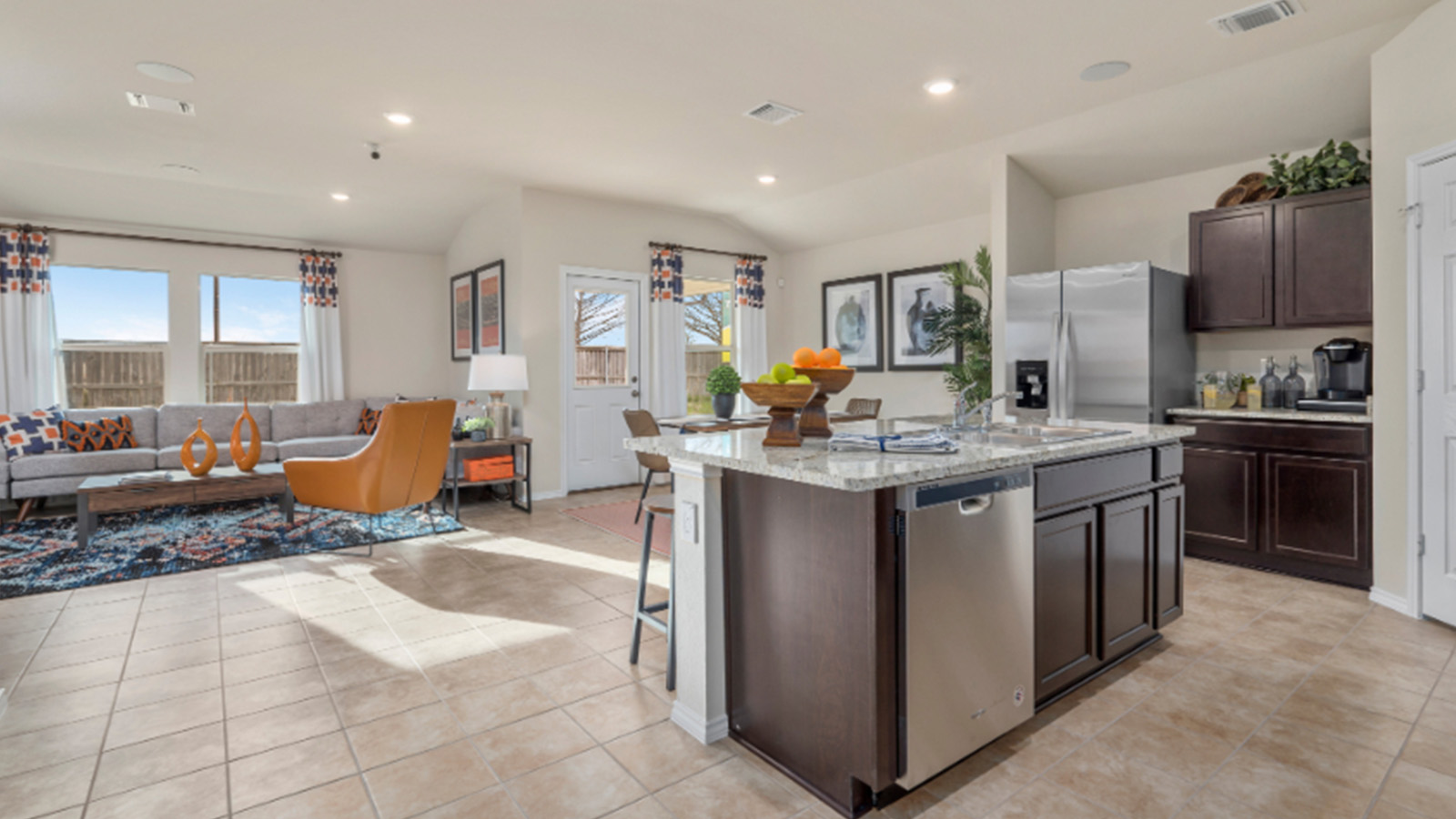 Yowell Ranch Model Home kitchen with kitchen island and view of open concept dining room and living room.