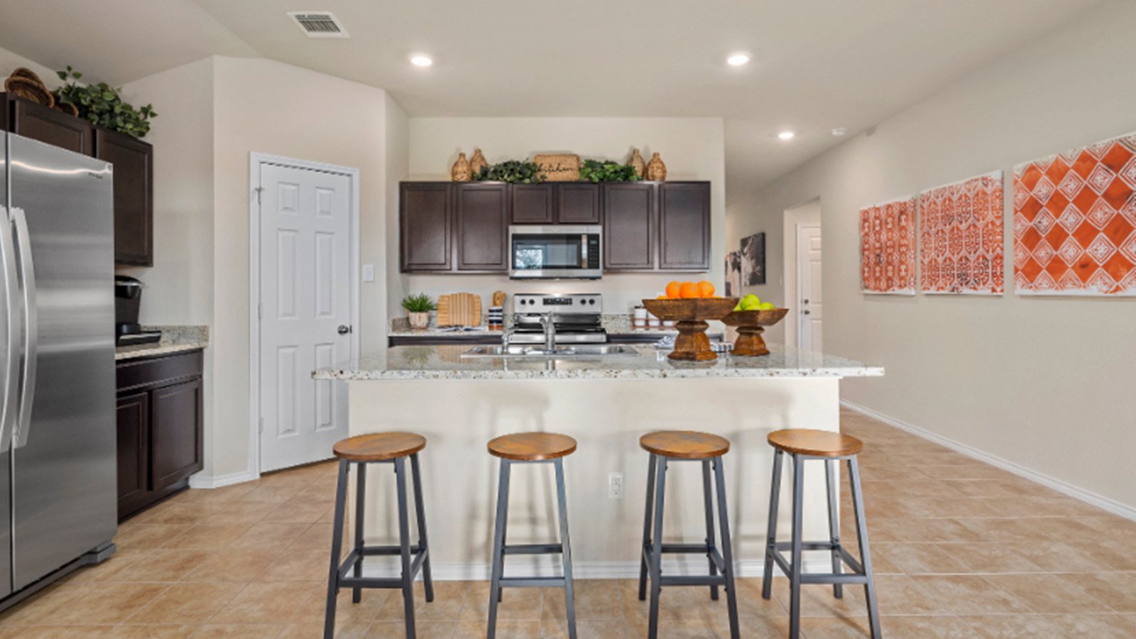 Yowell Ranch Model Home kitchen with kitchen island and dark cabinets and granite countertops.