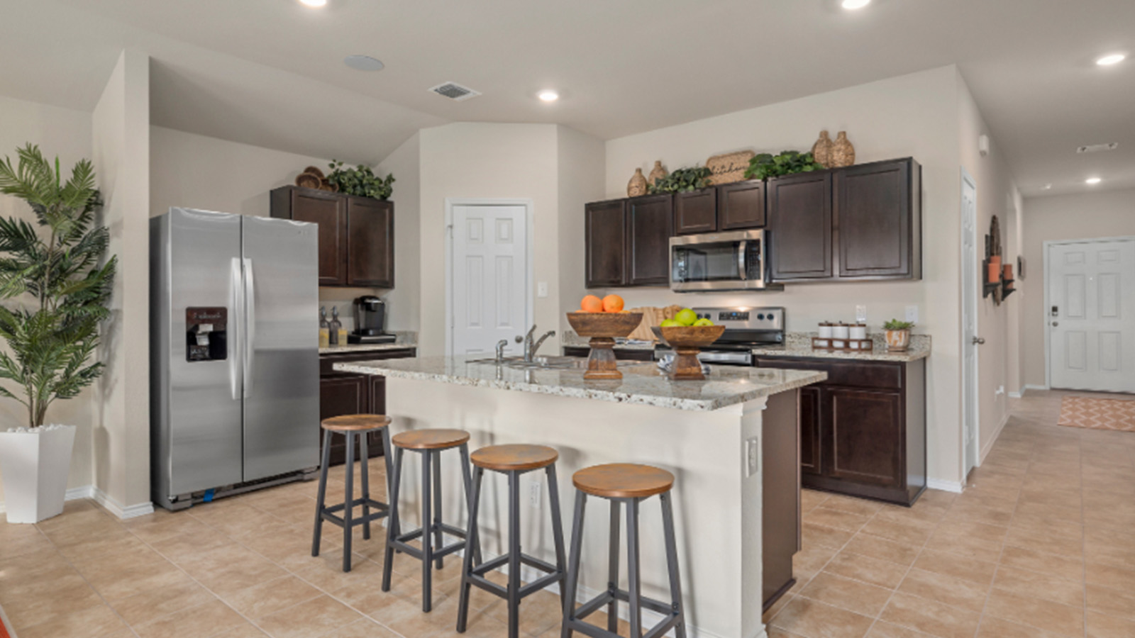 Yowell Ranch Model Home kitchen with kitchen island and view of front entry hallway.